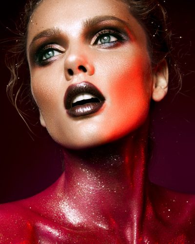 Beautiful woman with red make up and glitter on the neck and hair